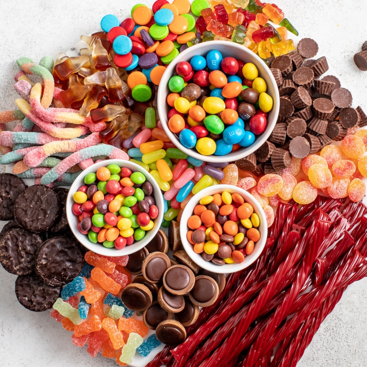 An assortment of delicious snacks, including crunchy chips, savory nuts, and colorful candies, neatly arranged on a serving platter.