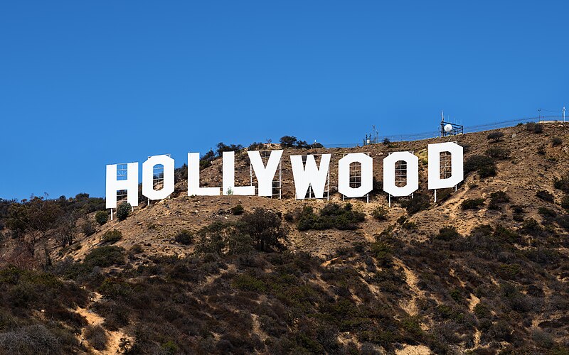 The iconic Hollywood sign standing tall against a clear blue sky, nestled in the hills overlooking Los Angeles.